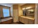 Bright bathroom featuring a soaking tub, single vanity with granite countertop, and tile flooring at 2749 Sand Oak Loop, Apopka, FL 32712