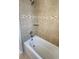Clean bathroom featuring a white tub, neutral tile, and decorative mosaic accent tiles at 2749 Sand Oak Loop, Apopka, FL 32712