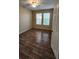 Cozy bedroom features wood-look tile flooring, ceiling fan, and natural light from two windows at 2749 Sand Oak Loop, Apopka, FL 32712