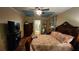 Spacious bedroom with wooden floors, tray ceiling, closet, and view into a bathroom at 2749 Sand Oak Loop, Apopka, FL 32712