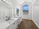 Bright bathroom with double sinks, large mirrors, modern fixtures, and luxury vinyl plank flooring at 3951 Haynes Cir, Casselberry, FL 32707