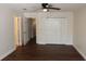 Bright bedroom featuring dark wood floors, closet, ceiling fan, and white trim at 4964 Luge Ln, Orlando, FL 32839