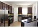 Bright kitchen has stainless steel appliances, dark cabinetry and tile flooring at 4964 Luge Ln, Orlando, FL 32839