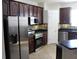 Well-lit kitchen features stainless steel appliances, dark cabinetry and stone countertops at 4964 Luge Ln, Orlando, FL 32839