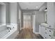 Bathroom showing tiled tub, wood floors, white cabinets and closet at 5243 W Lake Butler Rd, Windermere, FL 34786