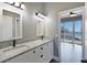 Bathroom featuring double sinks, granite counters, and view to bedroom and an outside balcony at 5243 W Lake Butler Rd, Windermere, FL 34786