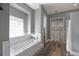 Bathroom featuring a tub with tiled surround, built-in storage, and wood flooring at 5243 W Lake Butler Rd, Windermere, FL 34786