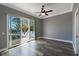 Bedroom with water view, fan, gray walls, and wide plank floors is bright and spacious at 5243 W Lake Butler Rd, Windermere, FL 34786