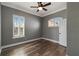 Bedroom with wide plank floors, ceiling fan, and two windows is bright and airy at 5243 W Lake Butler Rd, Windermere, FL 34786