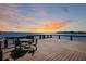 Wooden deck and railing with a table and chairs offering amazing waterfront views at 5243 W Lake Butler Rd, Windermere, FL 34786