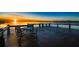 Waterfront deck with table and chairs overlooking a calm lake reflecting the orange colors of the sunrise at 5243 W Lake Butler Rd, Windermere, FL 34786