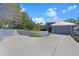 Modern blue home with metal roof, three-car garage, well-manicured lawn and a long concrete driveway at 5243 W Lake Butler Rd, Windermere, FL 34786