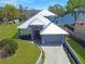 Aerial view of a beautiful waterfront home featuring a metal roof and well-manicured landscaping at 5243 W Lake Butler Rd, Windermere, FL 34786