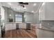 Open concept kitchen with granite countertops, white cabinetry, and stainless steel appliances and wood flooring at 5243 W Lake Butler Rd, Windermere, FL 34786