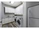 Laundry room featuring front load washer and dryer, granite counters, and white cabinets at 5243 W Lake Butler Rd, Windermere, FL 34786