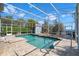 Inviting in-ground pool within a screened enclosure, complemented by a lush backyard and water views, ideal for relaxing at 5243 W Lake Butler Rd, Windermere, FL 34786