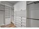 Spacious walk-in closet featuring custom shelving, drawers, and ample storage space with wood flooring at 5243 W Lake Butler Rd, Windermere, FL 34786