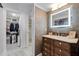 Elegant bathroom featuring a vanity, decorative textured wall, illuminated mirror and walk-in closet at 530 E Central Blvd # 705, Orlando, FL 32801