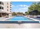 Large outdoor pool and lounge area with shade and lush vegetation at 530 E Central Blvd # 705, Orlando, FL 32801