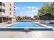 Sparkling pool with lounge area, cabana, and tropical plants on the pool deck near white condo building at 530 E Central Blvd # 705, Orlando, FL 32801