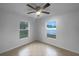 Bright bedroom featuring tile floors, ceiling fan and two windows that provide natural light at 546 Koala Dr, Kissimmee, FL 34759