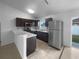 Modern kitchen with dark cabinetry, stainless steel appliances and a breakfast bar at 546 Koala Dr, Kissimmee, FL 34759