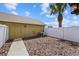 Enclosed backyard with a newly placed A/C unit, palm tree, and a white fence at 6633 Calamondin Dr, Winter Garden, FL 34787