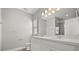 Bright bathroom features a double sink vanity with white cabinets and a modern lighting fixture at 6633 Calamondin Dr, Winter Garden, FL 34787