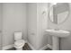 This is a well-lit powder room with pedestal sink and a round mirror at 6633 Calamondin Dr, Winter Garden, FL 34787