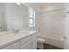 Bright bathroom featuring a vanity with quartz countertop, bathtub and shower combo, and window at 6633 Calamondin Dr, Winter Garden, FL 34787