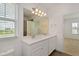 Bright bathroom featuring a double vanity with white cabinets and quartz countertop, plus a walk-in shower at 6633 Calamondin Dr, Winter Garden, FL 34787