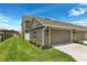 Home exterior featuring a two-car garage, green grass, and a well-maintained yard at 6633 Calamondin Dr, Winter Garden, FL 34787