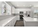 Modern kitchen featuring white cabinets, stainless steel appliances, stone countertops, and hardwood flooring at 6633 Calamondin Dr, Winter Garden, FL 34787