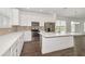 Well-lit kitchen with white cabinetry, stainless steel appliances, and a functional center island at 6633 Calamondin Dr, Winter Garden, FL 34787