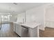 Open-concept kitchen with a white island, stainless steel dishwasher, and wood-look flooring at 6633 Calamondin Dr, Winter Garden, FL 34787