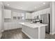 Modern kitchen featuring white cabinets, stainless steel appliances, stone countertops, and hardwood flooring at 6633 Calamondin Dr, Winter Garden, FL 34787