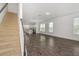 Bright living room featuring wood-look flooring and staircase, connected to a modern kitchen at 6633 Calamondin Dr, Winter Garden, FL 34787