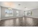 Spacious living room with wood floors, large windows providing natural light, and neutral paint at 6633 Calamondin Dr, Winter Garden, FL 34787