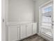 Practical mudroom features white shaker cabinets and a window for natural light at 6633 Calamondin Dr, Winter Garden, FL 34787