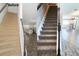 Carpeted staircase leads to an open concept living area, showing before-and-after renovations at 6633 Calamondin Dr, Winter Garden, FL 34787