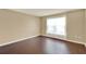 Neutral bedroom featuring hardwood floors and a bright window covered with sheer white curtains at 9649 Water Fern Cir, Clermont, FL 34711