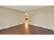 Neutral bedroom with hardwood floors, archway, and view of a brightly lit kitchen at 9649 Water Fern Cir, Clermont, FL 34711