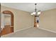 Dining room featuring a neutral color scheme, carpet, chandelier, and arched doorway to other living areas at 9649 Water Fern Cir, Clermont, FL 34711