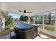 Relaxing screened-in porch featuring a modern hot tub and a view of the green backyard at 9649 Water Fern Cir, Clermont, FL 34711