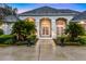 Inviting entrance with arched doorways, detailed landscaping, and decorative lighting at dusk at 1080 Edmiston Pl, Longwood, FL 32779