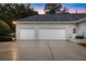 Spacious three-car garage with white doors and ample parking on the concrete driveway at 1080 Edmiston Pl, Longwood, FL 32779