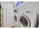 Bright laundry room with front loading washer and dryer, shelving, and ample storage space at 1080 Edmiston Pl, Longwood, FL 32779