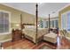 Spacious main bedroom with four-poster bed, hardwood floors, and natural light at 1080 Edmiston Pl, Longwood, FL 32779