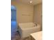 Bathroom featuring a large bathtub with tile surround, modern fixtures, and wood flooring at 115 Royalty Cir, Sanford, FL 32771