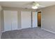 Bedroom featuring plush gray carpeting, a ceiling fan, and multiple closets for ample storage at 115 Royalty Cir, Sanford, FL 32771